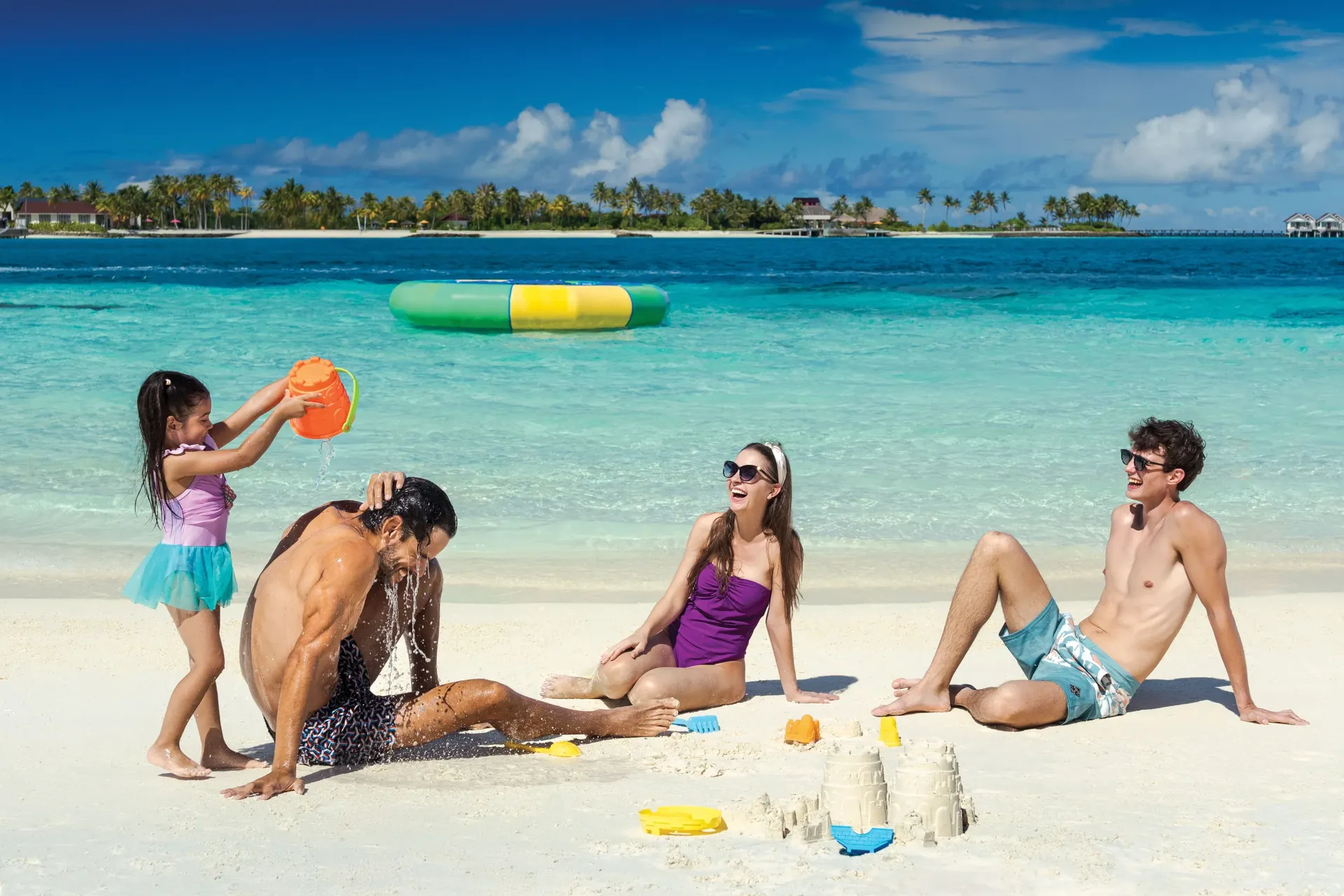 Family building sandcastles on a Maldives beach