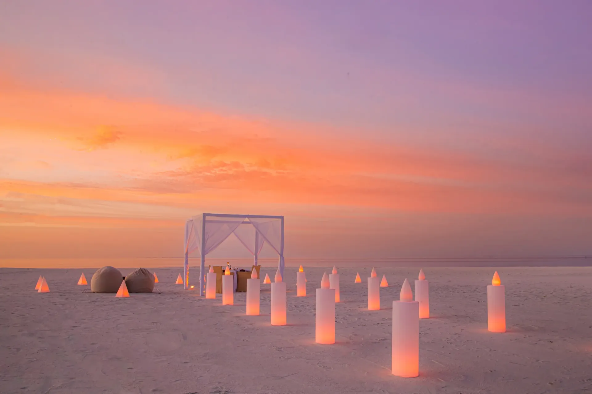 Candlelit dinner for two on the beach at sunset